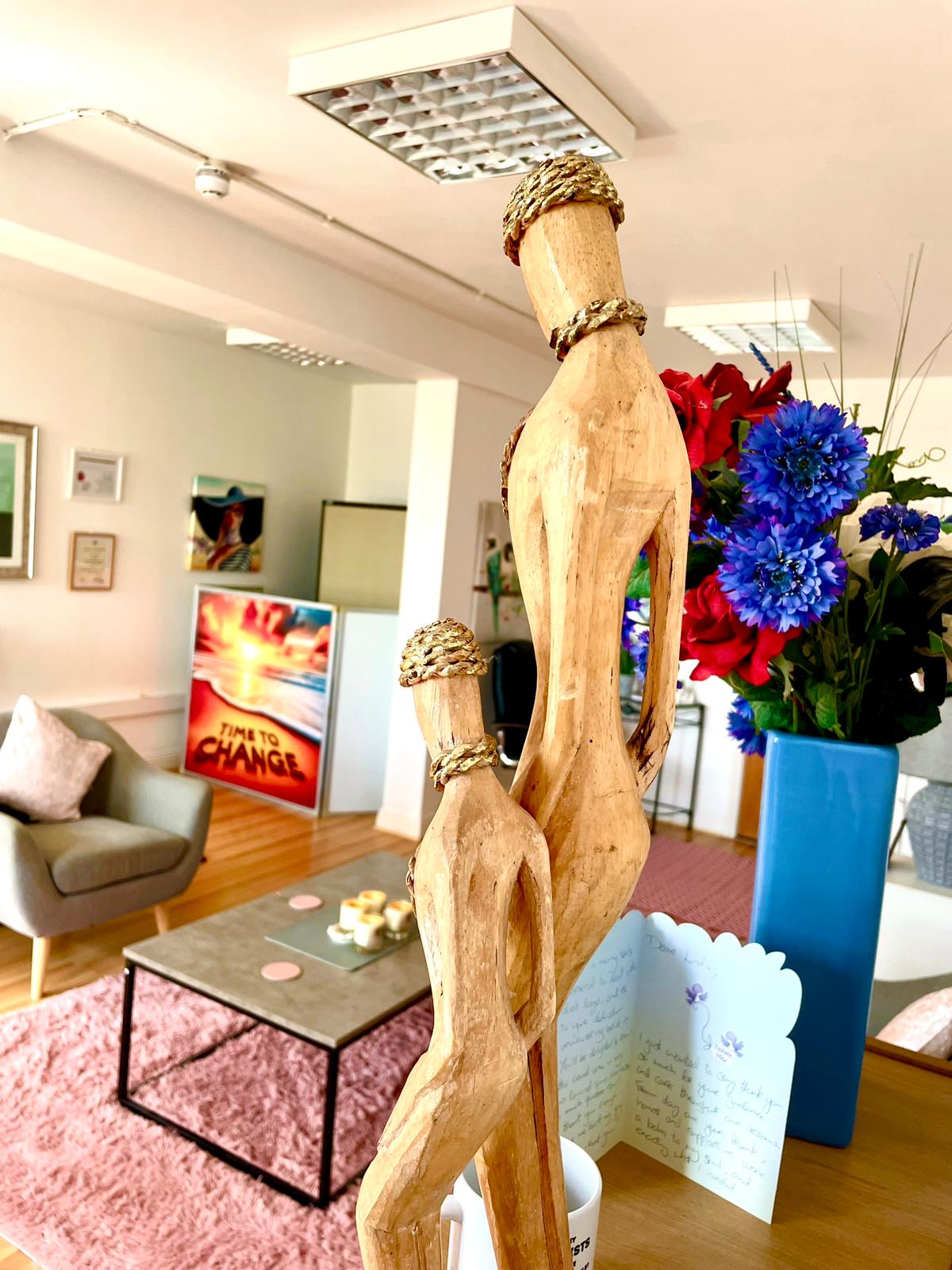 Hand-carved wooden sculpture in the therapy room — a symbol of connection and growth